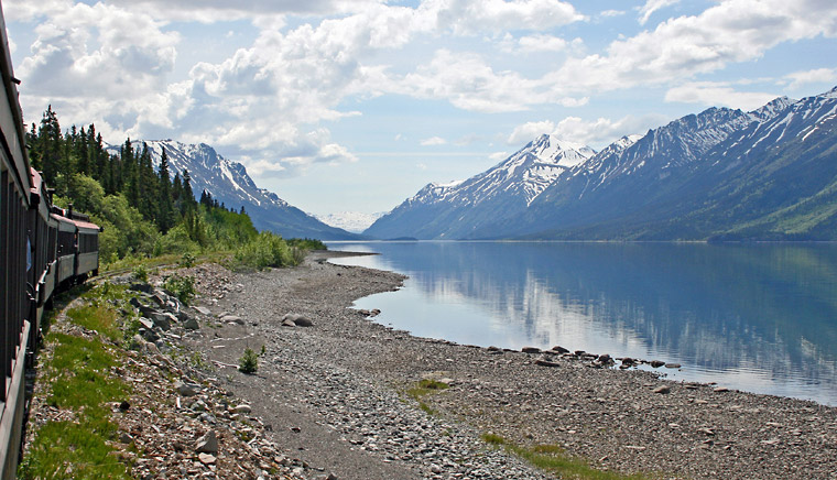 Photo of train riding along Bennett Lake, on route to Bennett, British Columbia
